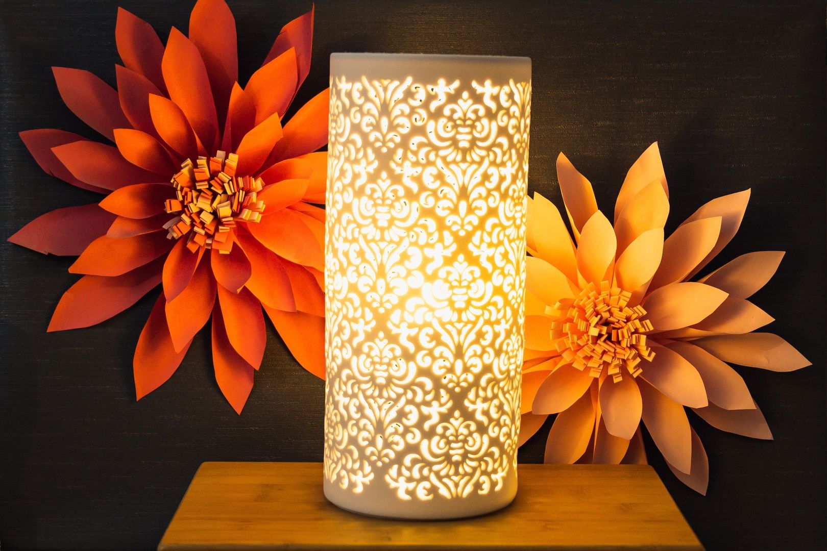 Eine Lampe vor einen Blumenwand die eine dekorative Note verleiht.